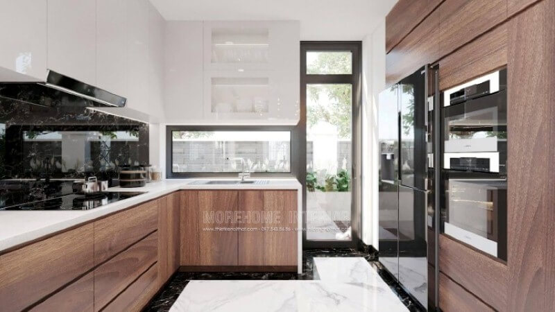 Là một trong những xu hướng trang trí nội thất ấn tượng trong những năm tới, trang trí phòng bếp hiện đại tôn lên vẻ đẹp mộc mạc nhưng không kém phần sang trọng của gỗ điển hình là gỗ óc chó tự nhiên. Loại gỗ rất được ưa chuộng trong các siêu xe bởi vẻ đẹp ấn tượng từ vân, màu gỗ. Như trong ý tưởng bố trí phòng bếp tại biệt thự Vinhomes Imperia, sự hài hòa tôn lên nét đẹp giữa truyền thống và hiện đại, tủ bếp dưới gỗ óc chó và tủ bếp trên gỗ công nghiệp trắng bóng. Tủ bếp gỗ công nghiệp và tủ bếp acrylic